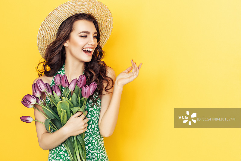 手捧紫色郁金香的迷人女性图片素材