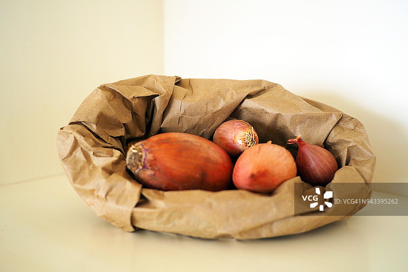 黑色背景上装有红洋葱的纸袋图片素材