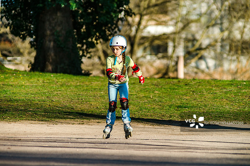 在公园里学习轮滑的可爱小女孩图片素材