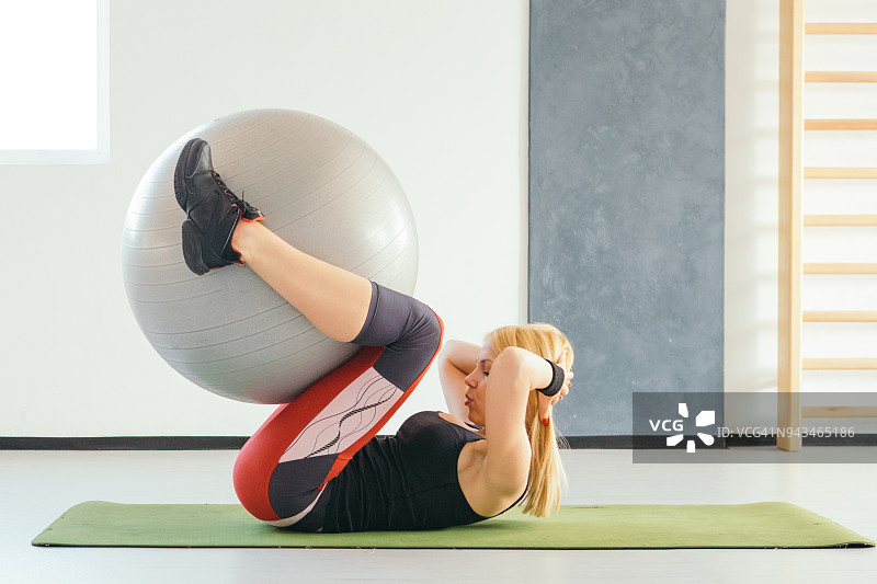 健身女人用普拉提球做腹部运动图片素材