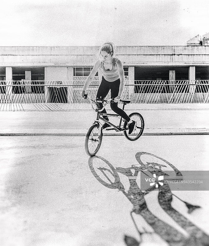 年轻女子骑着平地花式小轮车图片素材