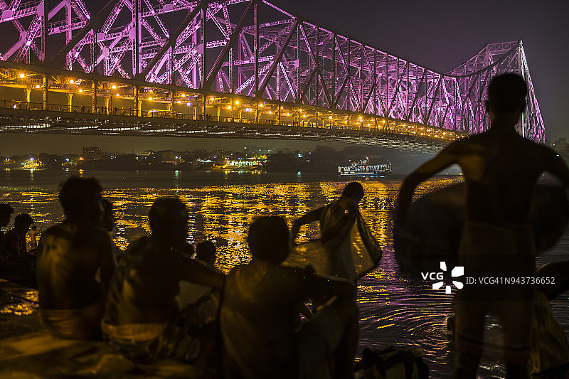 豪拉桥夜景与河中沐浴的人们图片素材