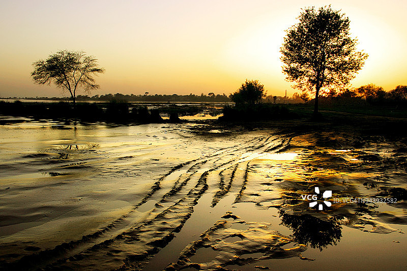 河滩沙地上轮胎印和日落图片素材