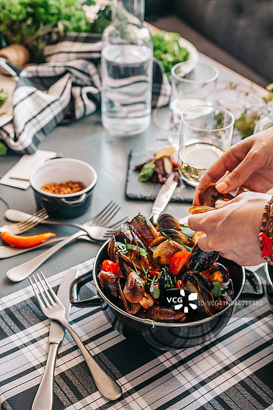 煮熟的贻贝配樱桃番茄和绿色香料图片素材