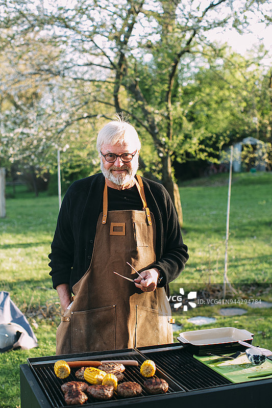 男子在花园烧烤图片素材