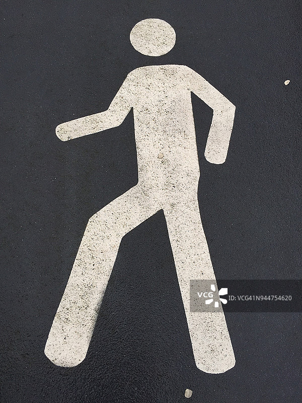 深灰色沥青路面上白色的行人标记图片素材