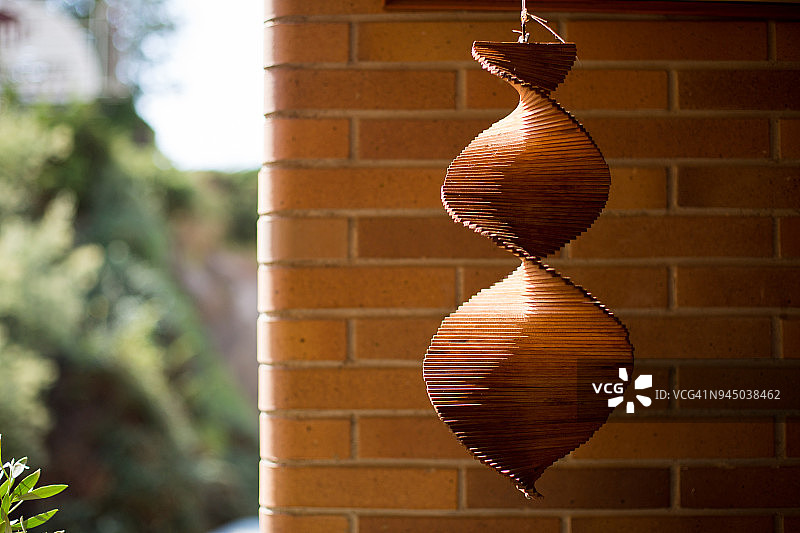 阳光照射下的木制手机，背景是砖墙和植被图片素材