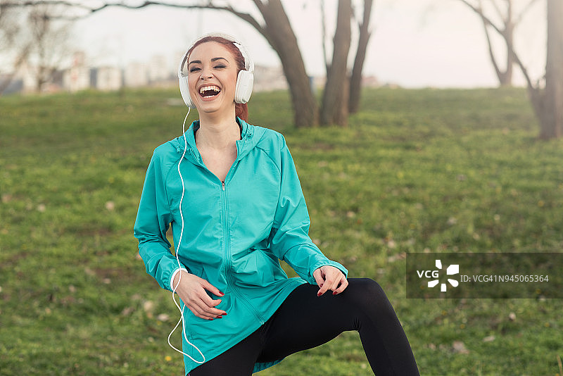 戴着耳机在户外训练中玩耍的健身女孩图片素材