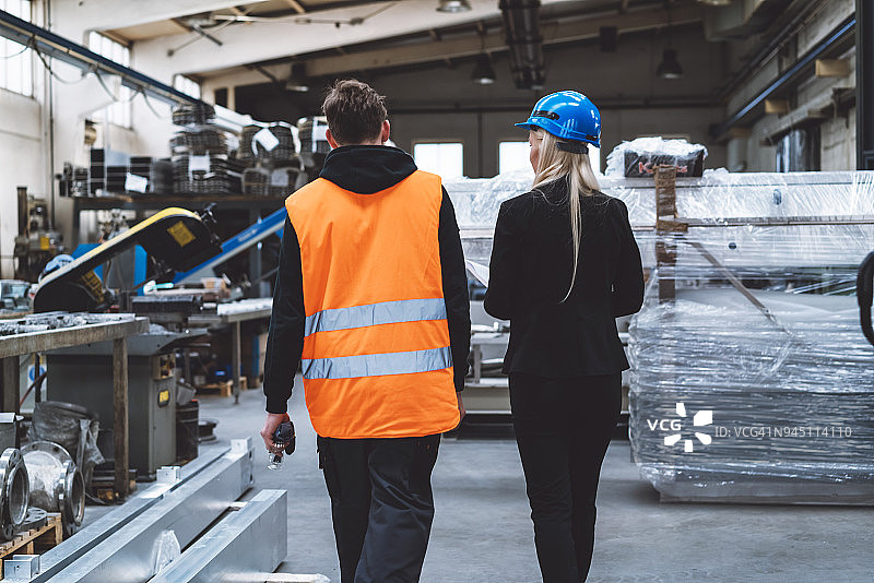 女主管和工人在仓库中行走图片素材