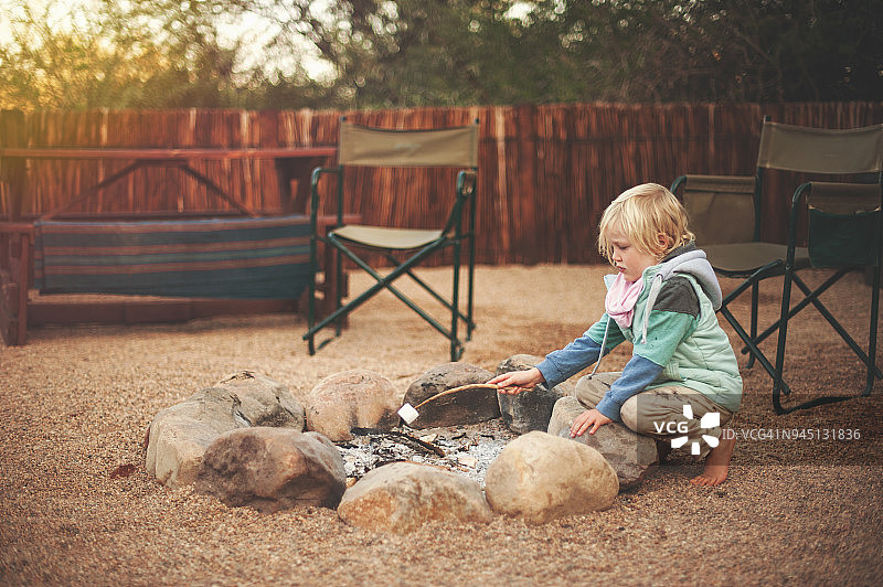 年轻女孩在篝火旁烤棉花糖图片素材
