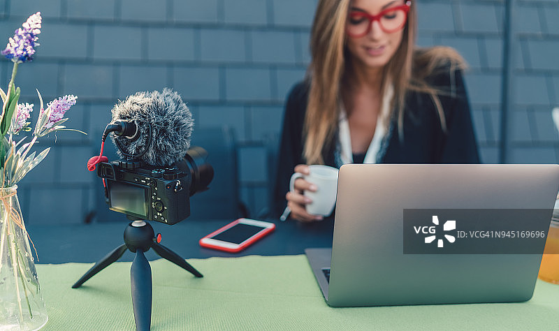 年轻女人在屋顶露台录制视频博客图片素材