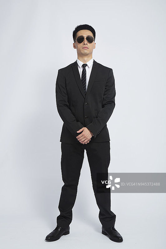 保镖戴着墨镜站在白色背景前图片素材