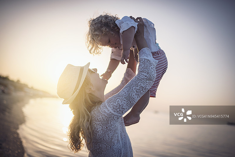 日出时在海滩上的母子图片素材