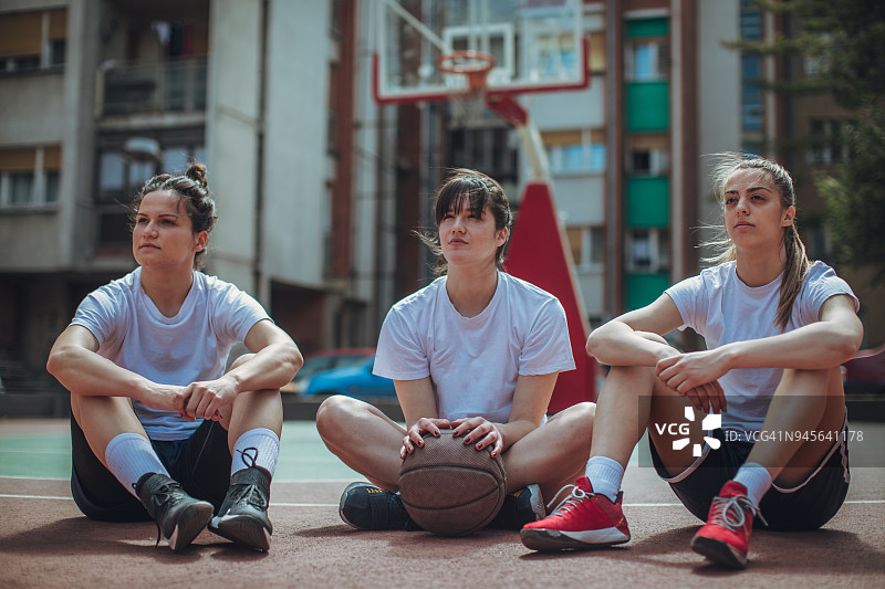 坐在球场上的街头女篮球运动员图片素材