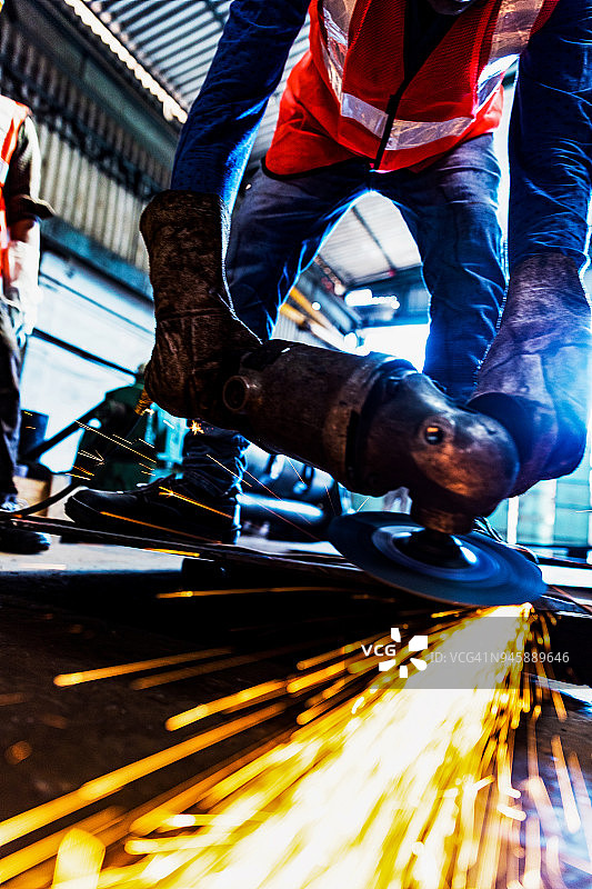 男人打磨金属时火花飞向镜头图片素材