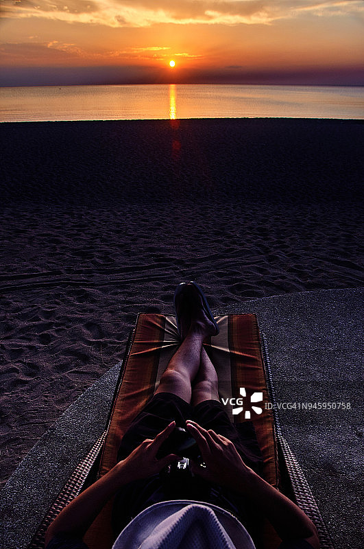 游客在海滩欣赏日落美景的剪影图片素材