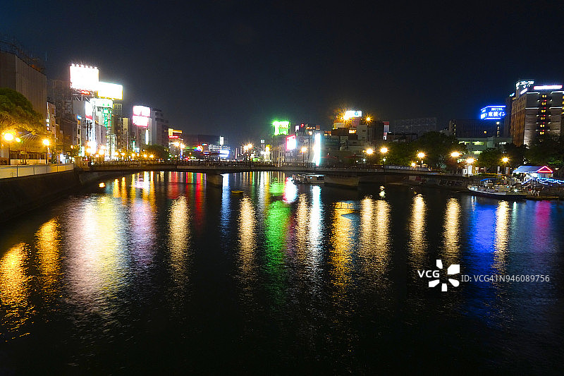 日本福冈市博多区那珂川的夜间灯光倒影图片素材