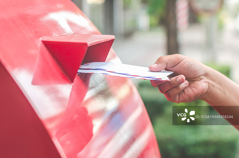 邮递员将信件放入邮箱的特写镜头图片素材