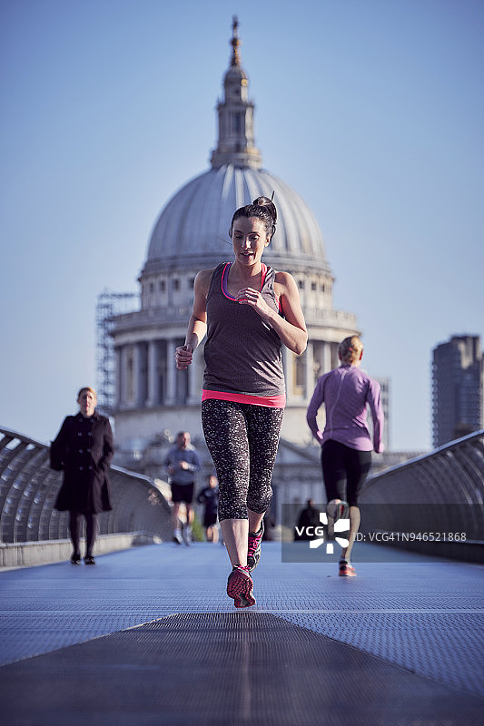 女人在伦敦千禧桥上奔跑图片素材