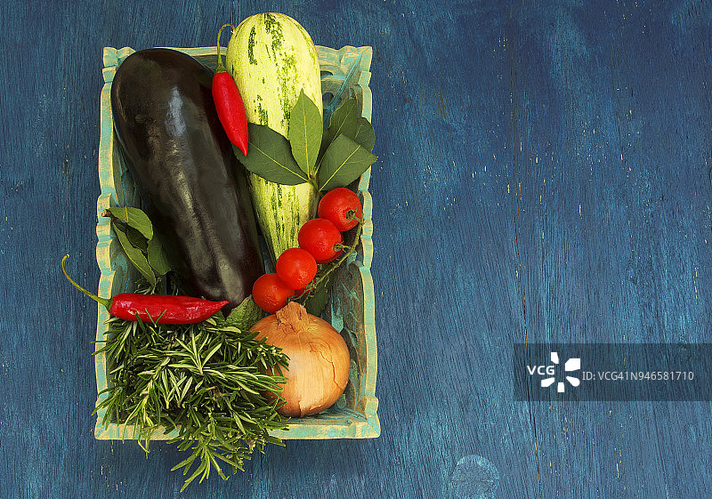 蓝色背景上的各种蔬菜和调味料篮图片素材