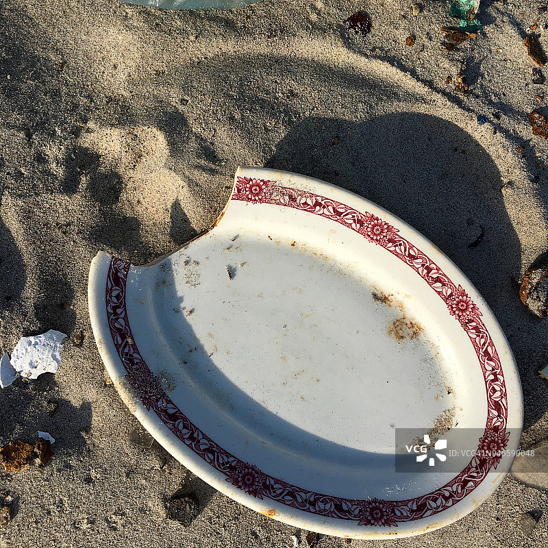 在纽约死亡马湾海滩上冲刷上来的旧盘子，该海滩曾经是城市规划师罗伯特·摩西拆除房屋期间穷人家庭用品的倾倒场图片素材
