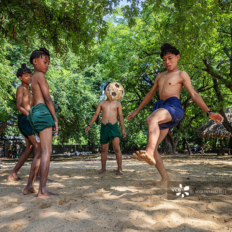 在缅甸蒲甘附近村庄玩藤球的缅甸男孩图片素材