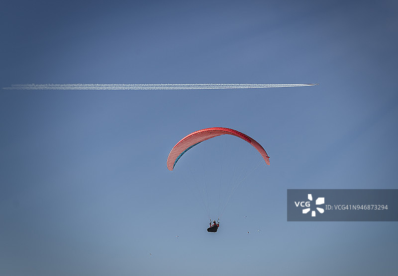 滑翔伞与商业喷气机气流图片素材