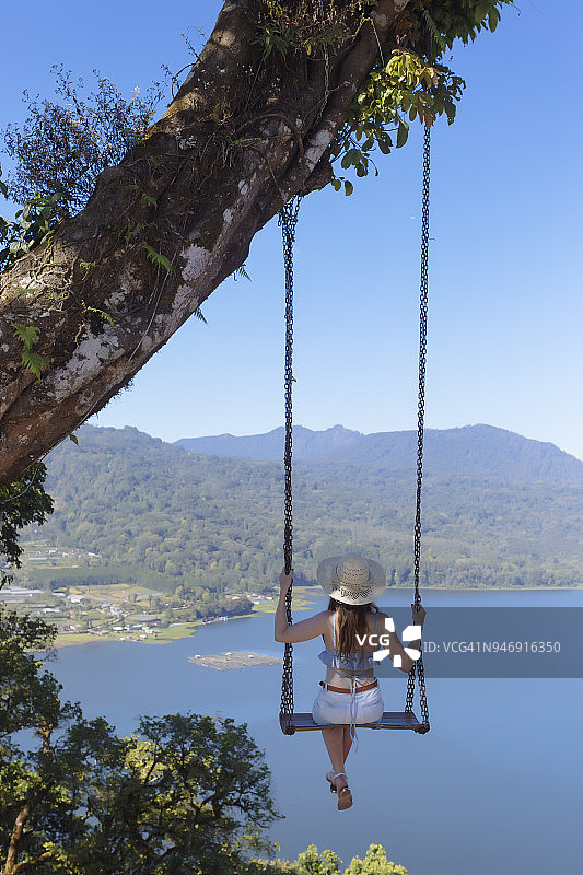 印度尼西亚巴厘岛坐在秋千上的年轻女子图片素材