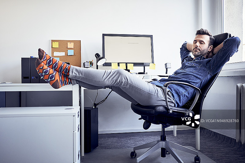 男人坐在办公室的办公桌前小睡图片素材