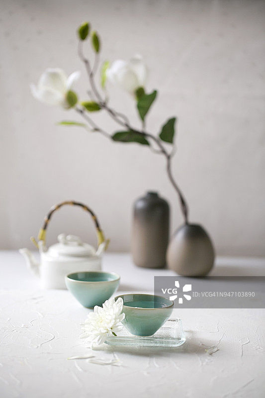 白色桌面上的绿色茶杯中的中国茶图片素材