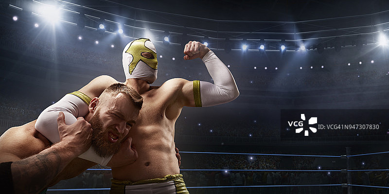 摔跤表演：两位摔跤手在擂台上穿着鲜艳的运动服和面罩搏斗图片素材