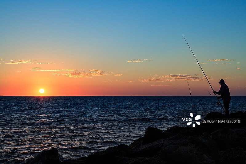 男人在日落时钓鱼图片素材