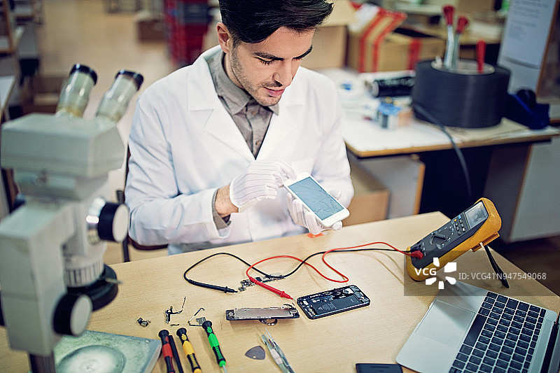 男子在维修店更换手机屏幕图片素材