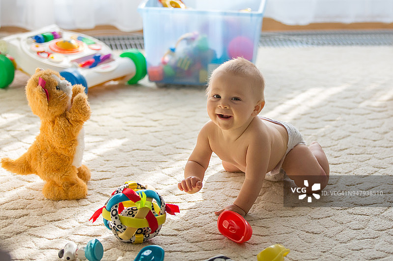 幼儿宝宝在阳光明媚的客厅里玩玩具图片素材