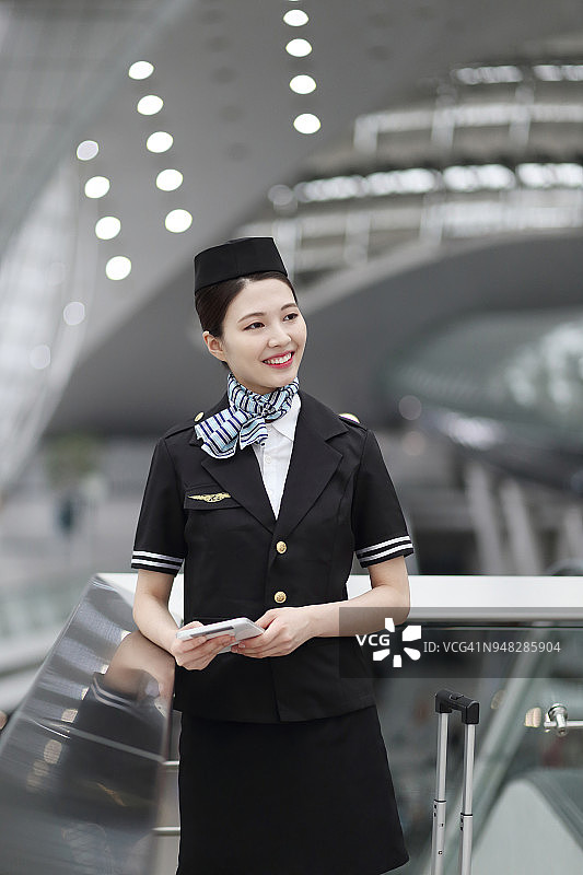 在机场使用平板电脑的微笑空姐图片素材