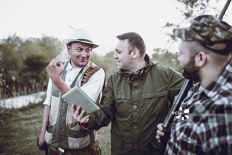 猎人团队在野外使用平板电脑查找GPS坐标图片素材