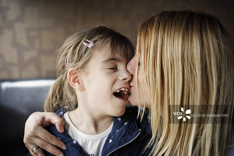 母亲亲吻视力受损的女儿图片素材