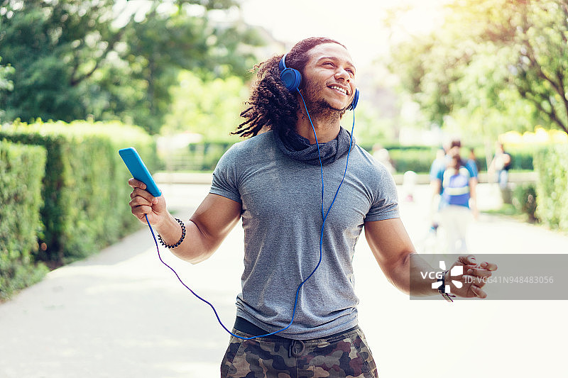 在公园里听音乐跳舞的快乐男人图片素材