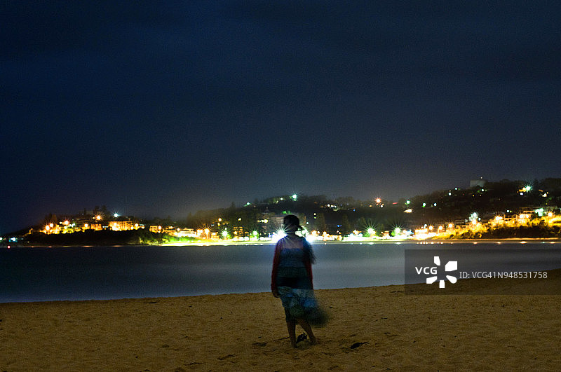夜晚站在海滩上的女孩长曝光图片素材