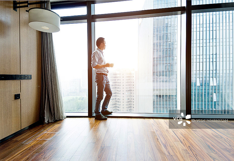 站在窗边喝咖啡的商人图片素材