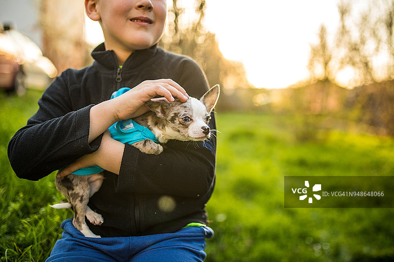 拥抱小狗的白人男孩图片素材