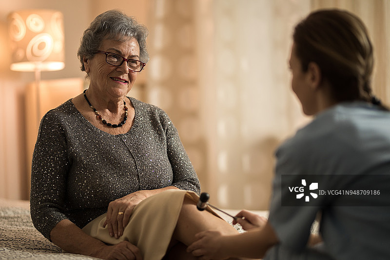 护士检查老年妇女的反射图片素材