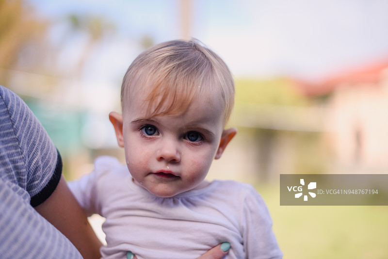 一周岁女孩在妈妈的怀里看着镜头图片素材