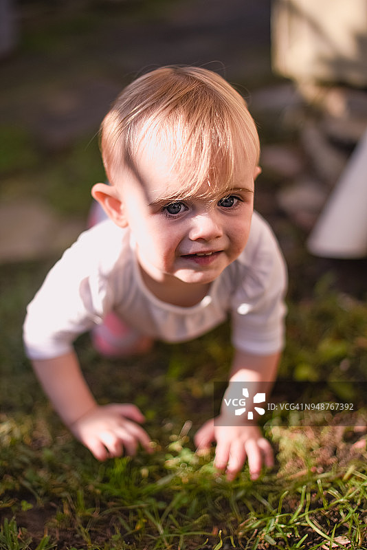 一岁女孩在草地爬向镜头图片素材