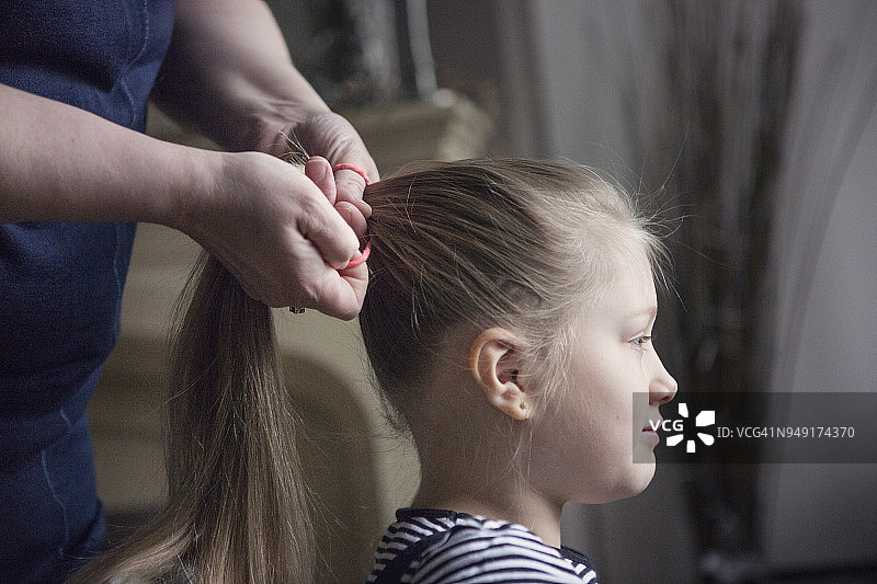 母亲为女孩（8-9岁）梳头图片素材