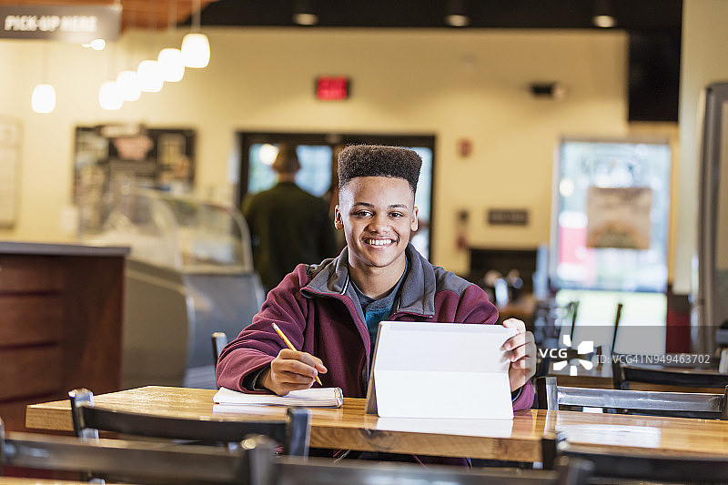 在餐厅学习的混血青少年男孩图片素材