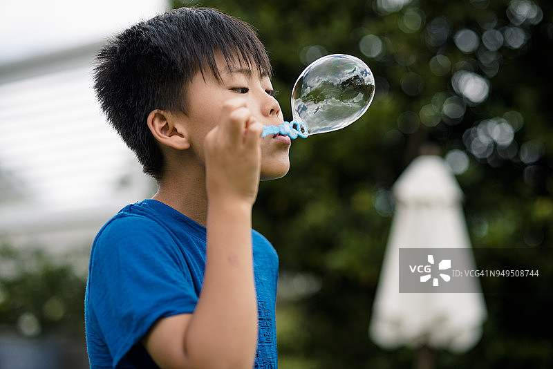 男孩在户外吹泡泡图片素材