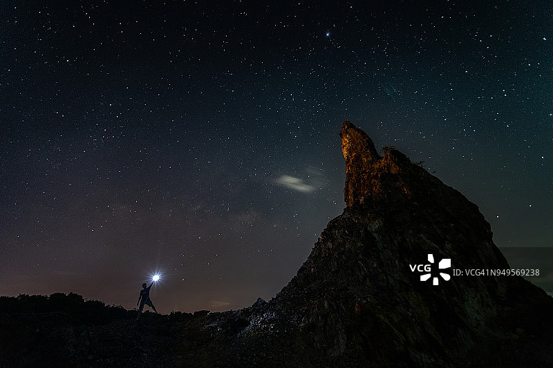 山丘上拿着火炬的人与银河图片素材