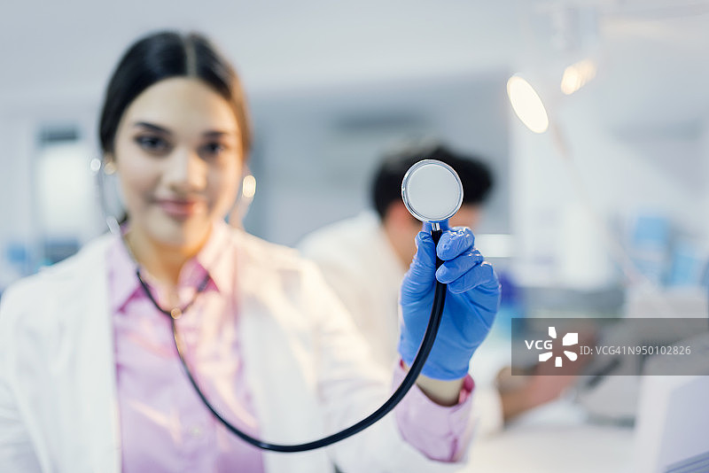 微笑的科学家使用听诊器并看向镜头的肖像图片素材