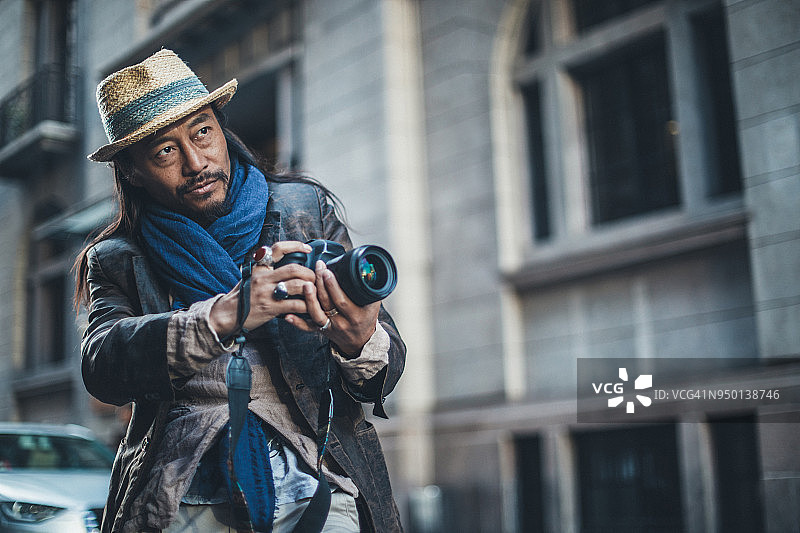 在市区的年长摄影师图片素材